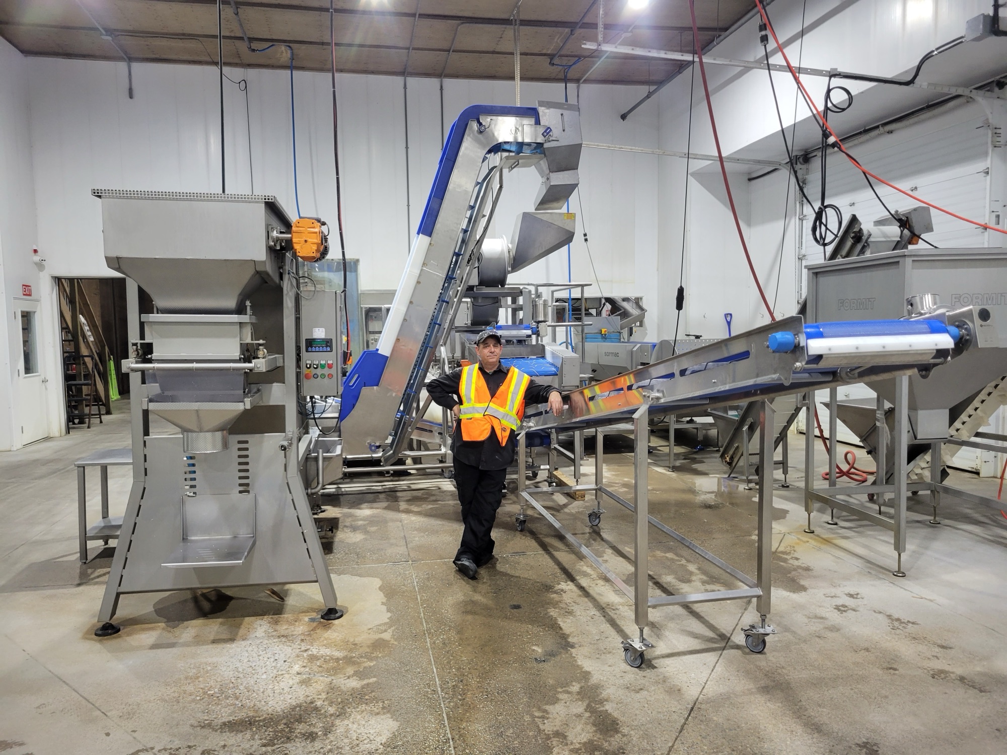 Operator standing beside a PLM line installed and running on a plant floor